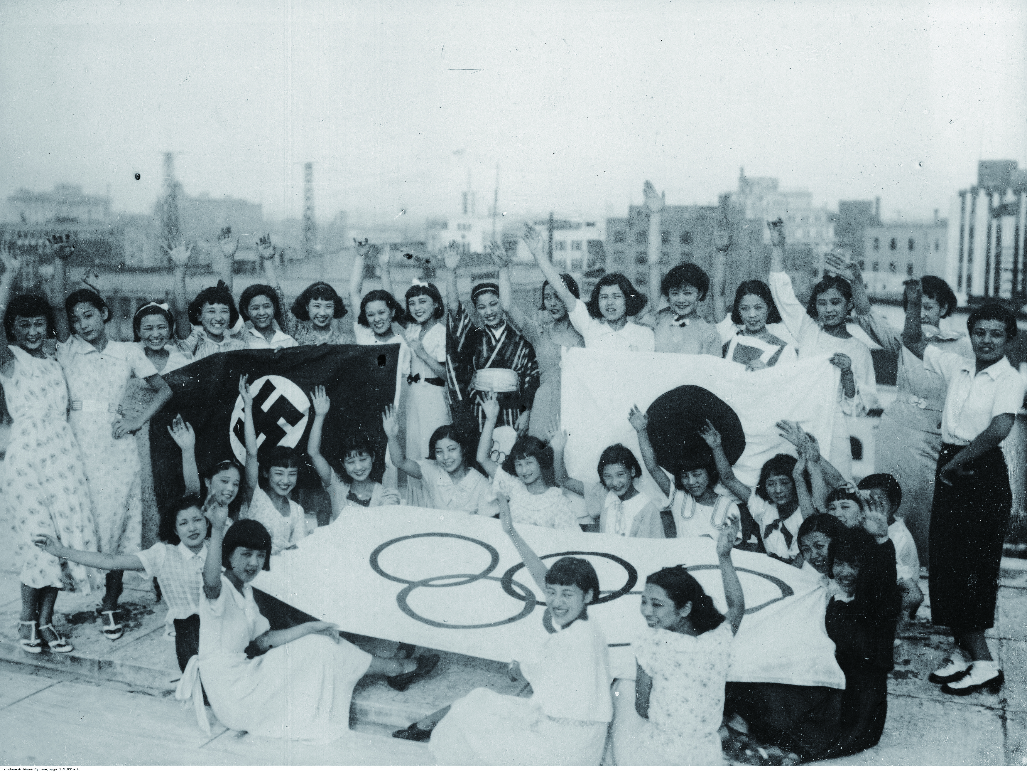 사진1_일본 여배우들과 나치기, 일장기, 올림픽기-1936년 도쿄 다카라즈카 극장(東京宝塚劇場, 현 도호(東宝))의 여성 배우들이 나치, 일본, 올림픽기 앞에서 포즈를 취했다.(출처폴란드 국립디지털아카이브)